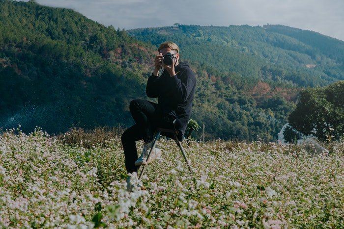 Fotógrafo aficionado en un campo de flores 