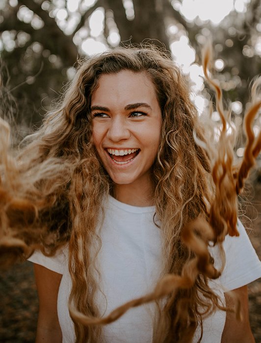 Retrato de una chica rubia, su cabello volando hacia la cámara.  Consejos para la fotografía de autorretratos.