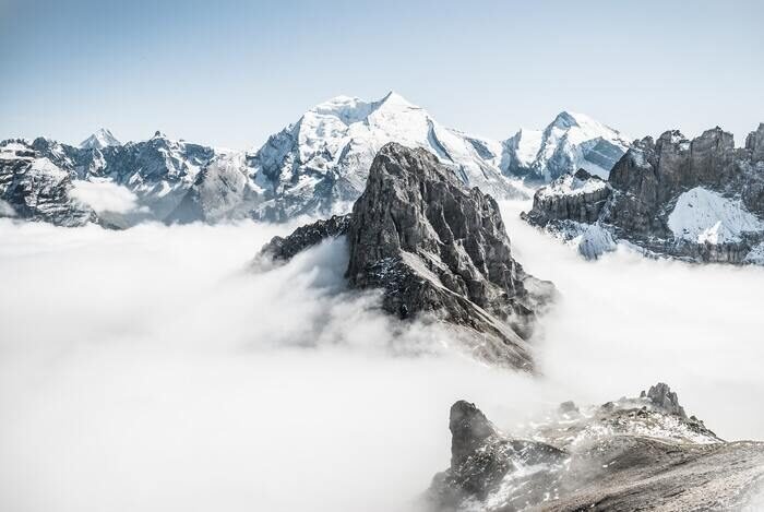 Foto de un pico de alta montaña con nubes a su alrededor