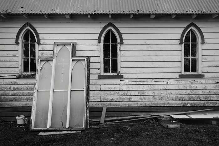 Fotografía documental en blanco y negro de la iglesia de Whare Karakia en espera de reparaciones