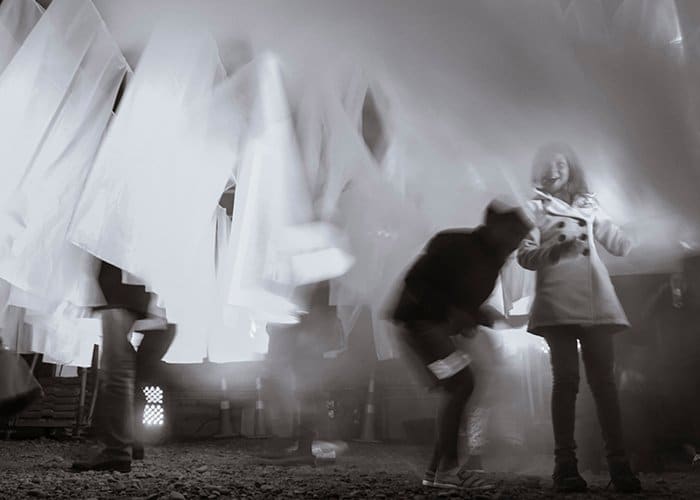 movimiento y desenfoque en la fotografía documental: fotografía en blanco y negro que utiliza una velocidad de obturación lenta de personas que se mueven entre material blanco 