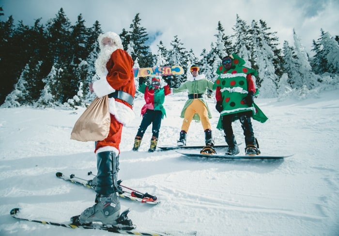 Papá Noel y un grupo de personas con trajes navideños patinando sobre hielo - tutoriales de fotografía navideña