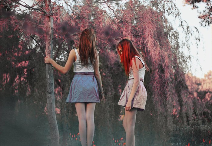 Retrato de ensueño de dos chicas con un fondo de bosque borroso. 