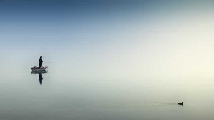 foto de un pescador en un barco en un lago