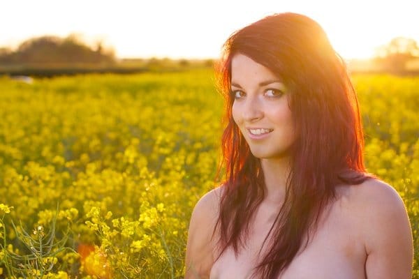 Foto de una mujer joven en el campo de flores amarillas demostrando edición con saturación