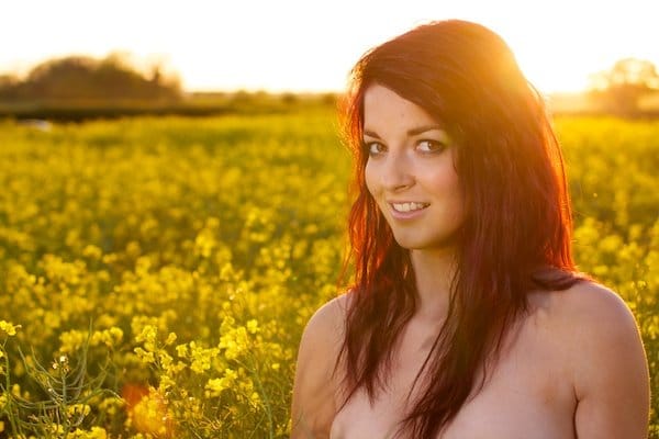 Foto editada de una mujer joven en el campo de flores amarillas