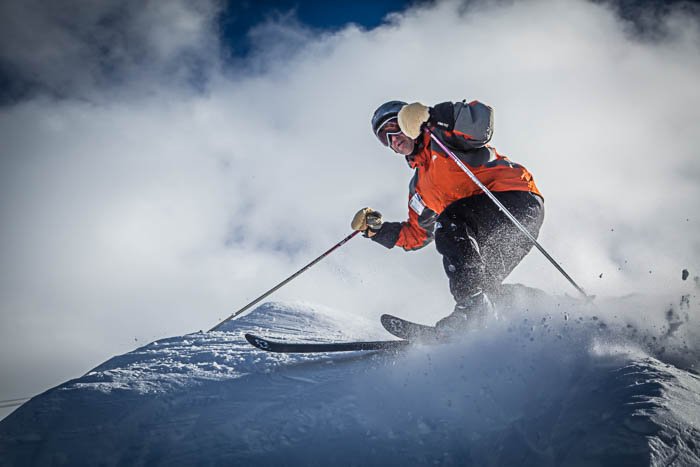 Imagen de un esquiador girando, con nieve en polvo volando por todas partes.
