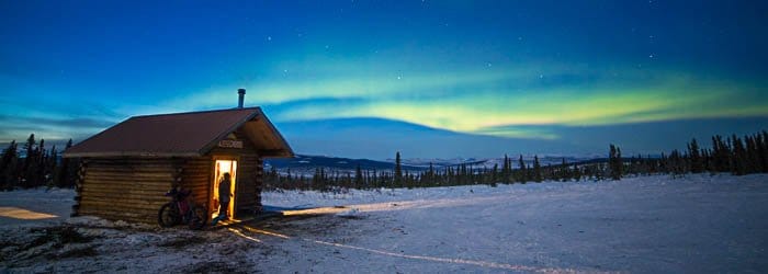 Imagen de una cabaña de Alaska con una vista del cielo de fondo.