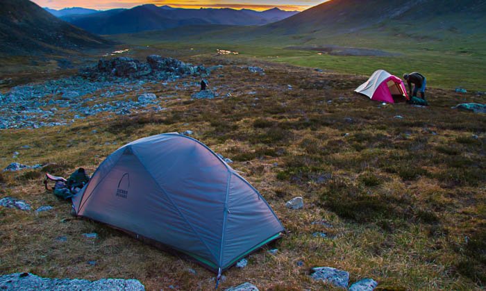 Fotografía de paisaje con una carpa en primer plano y otra de fondo