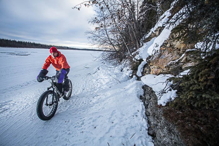 Fotografía de aventuras que muestra a un hombre montado en una fatbike en un paisaje invernal