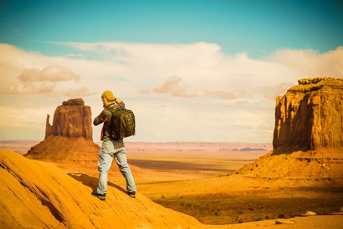 un excursionista de pie en un paisaje desértico rocoso - habilidades de fotografía de aventuras