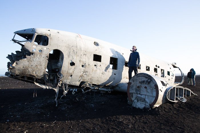 Imagen de un hombre en el ala de un avión abandonado, parte de la Flota Fantasma de Islandia