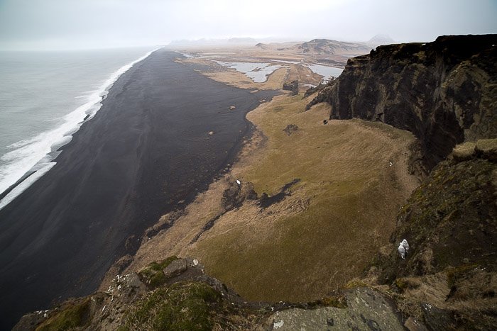 Fotografía de paisaje tomada desde arriba de la playa de arena negra en Islandia