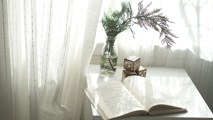 Bodegón de ensueño de un libro y un ramo de flores sobre una mesa blanca 