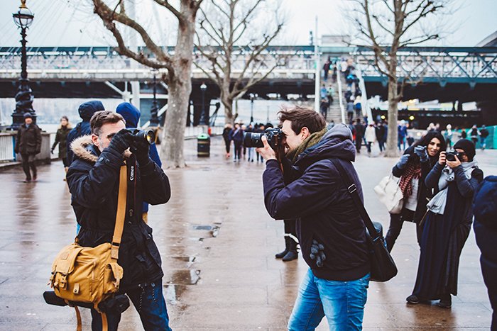 un grupo de personas fotografiando imágenes estéticas de fotografía callejera al aire libre 