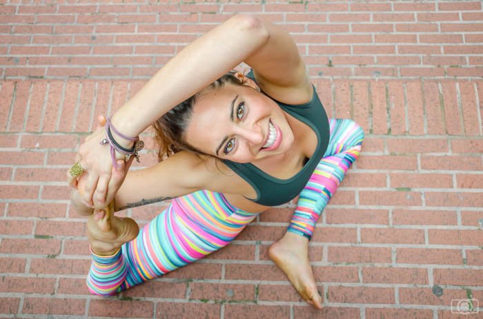 Foto de ángulo alto de un modelo de yoga vistiendo leggings brillantes y sonriendo a la cámara