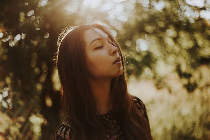 Retrato atmosférico al aire libre de una modelo femenina con luz ambiental de la hora dorada