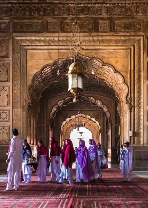El elemento humano en la fotografía de arquitectura: un grupo de personas caminando por la mezquita Badshahi en Lahore, Pakistán