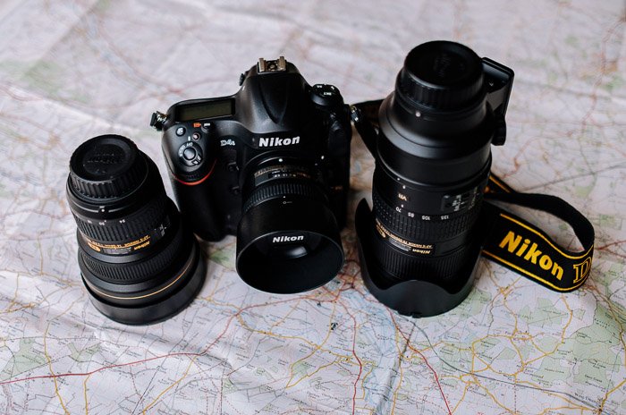 Cámara Nikon y equipo de cámara descansando sobre un mapa