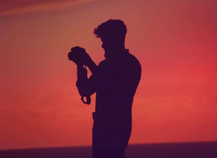 La silueta de un fotógrafo contra un impresionante cielo anaranjado 