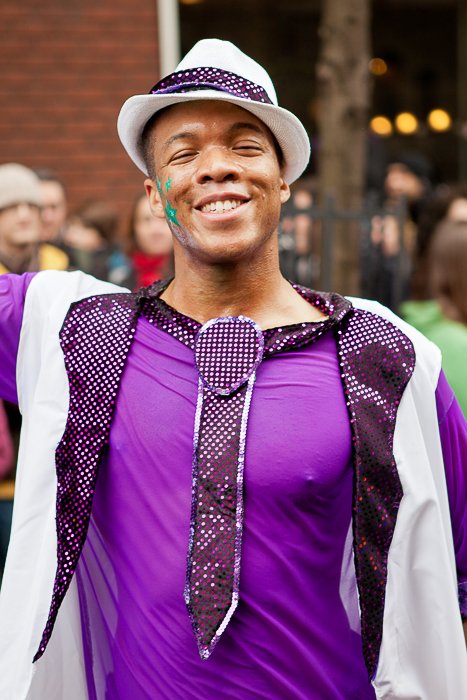 Una fotografía de carnaval de un hombre vestido de púrpura sonriendo a la cámara