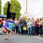 Un chico break dance en el Thames Festival con una multitud mirando