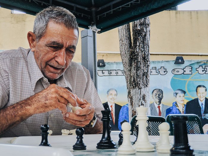 Un anciano jugando al ajedrez al aire libre