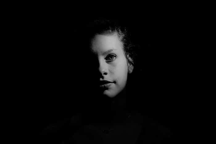 Retrato atmosférico de una modelo femenina filmada con iluminación de claroscuro
