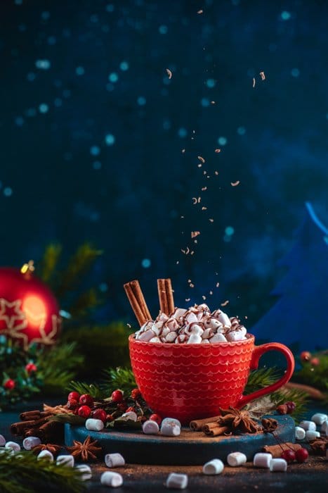 Geniales fotos navideñas bodegón de migas de chocolate levitando sobre una taza de chocolate caliente en un bodegón configurado