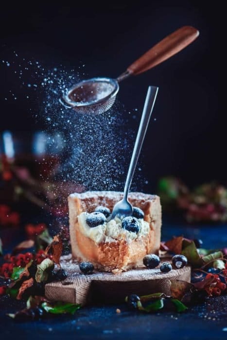 Geniales fotos navideñas de bodegón de azúcar y colador levitando sobre una rebanada de pastel