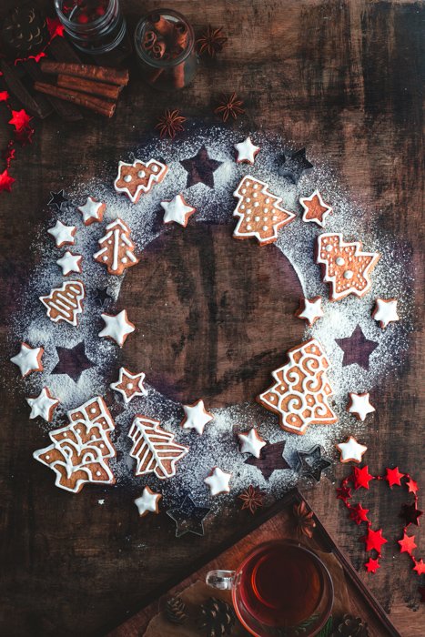 una corona navideña plana hecha de azúcar en polvo, galletas de jengibre y estrellas