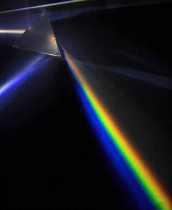 Imagen de rayos de luz blanca que atraviesan un prisma, lo que da como resultado un efecto de arco iris.