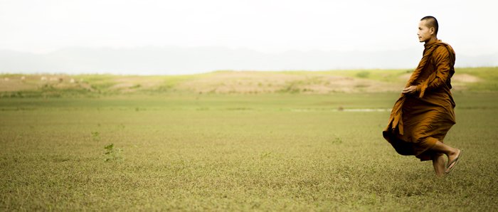 Fotografía cinematográfica luminosa y aireada retrato de un monje en un campo verde