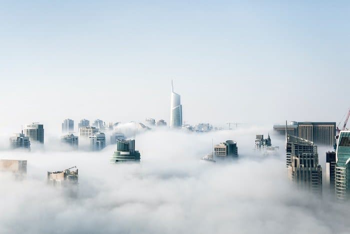 Una fotografía de los rascacielos de la ciudad atravesando las nubes.