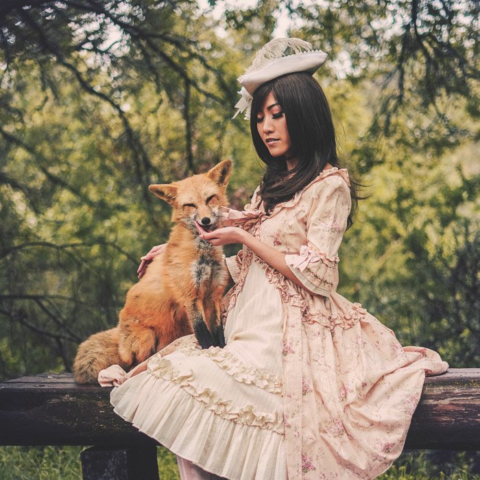 Un retrato de estilo vintage de un modelo femenino en traje de estilo antiguo sosteniendo un zorro 