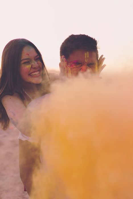 Foto de una niña y un niño con un fondo simple detrás de un polvo de color amarillo