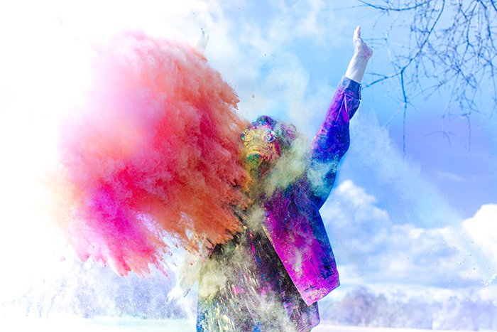 Foto de un hombre con chaqueta de color con una nube de polvo naranja frente a él