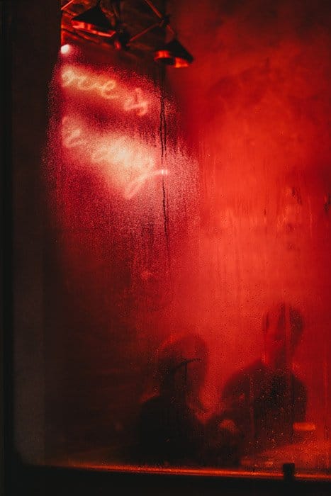 Foto de un bar con luz roja reflejada en la ventana