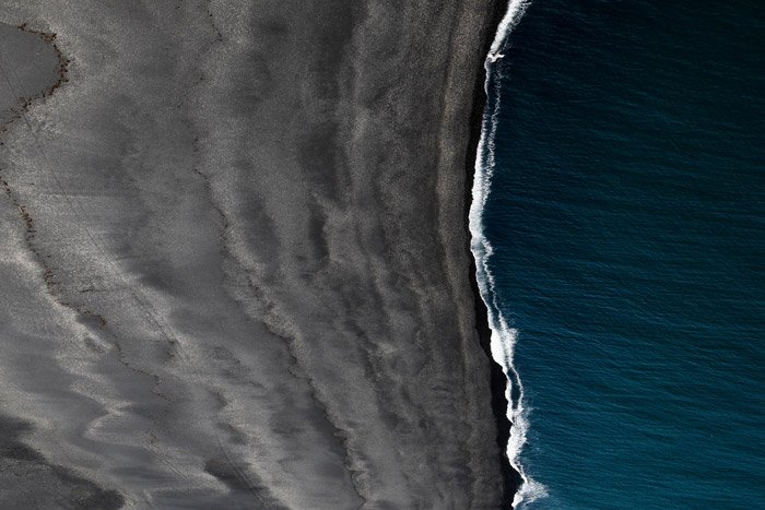 Fotografía aérea del paisaje del mar entrando en una playa: uso de la teoría del color en fotografías de paisajes