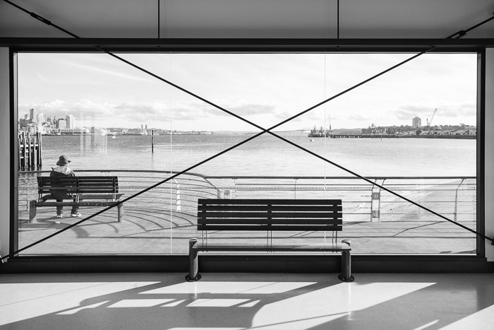 Una fotografía callejera en blanco y negro de Devonport, Auckland, bajo el sol brillante.