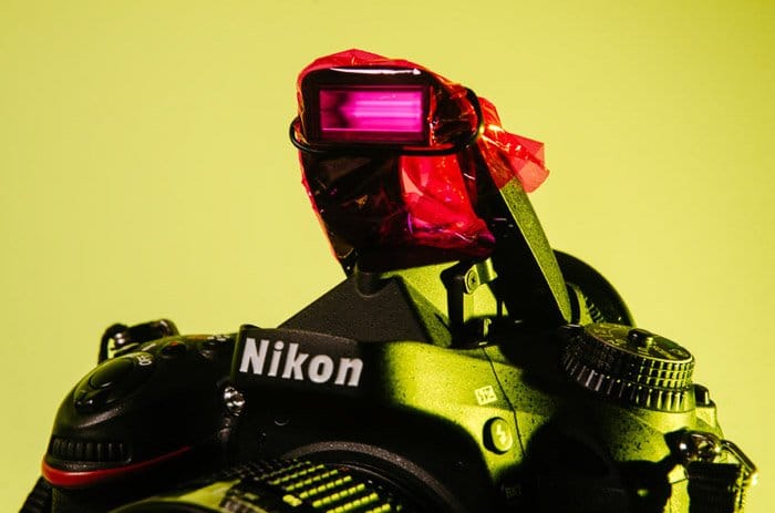 Cerca de una cámara Nikon con celofán rosa que cubre el flash - Fotografía de gel de color