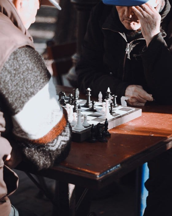 Fotografía de ajedrez sincero de dos hombres jugando una partida de ajedrez al aire libre