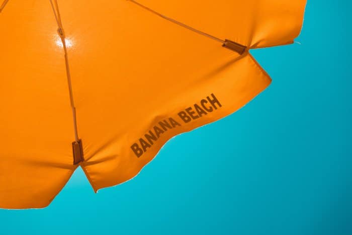 Una sombrilla naranja se sienta frente a un cielo azul acogedor