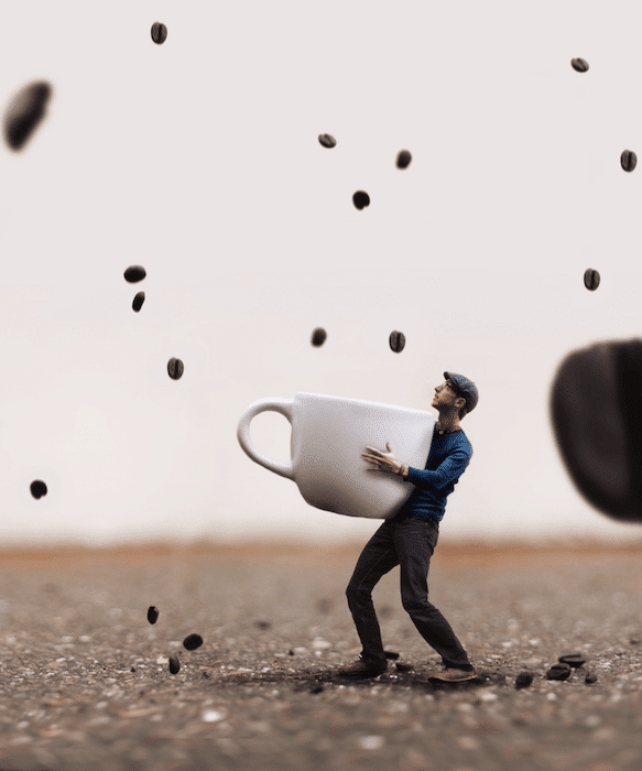 Imagen de fotografía compuesta de un hombre sosteniendo una taza con granos de café cayendo como lluvia a su alrededor