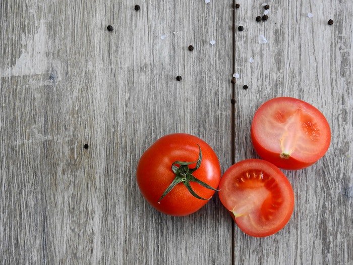 El contraste de color entre los tomates y la madera ayuda a crear una composición equilibrada que llama la atención.
