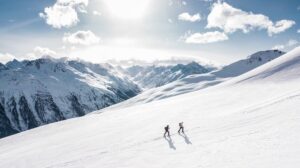 Dos excursionistas caminando sobre una montaña con un peso visual equilibrado de las montañas en el fondo