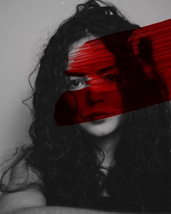 Retrato en blanco y negro de una mujer editada con una racha de pintura roja 