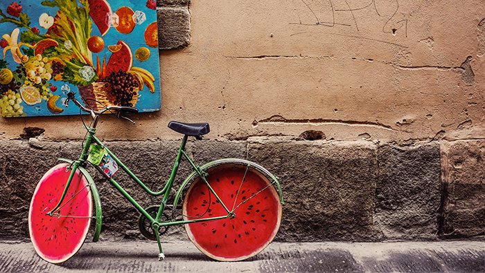 Una foto de la calle de una bicicleta con ruedas pintadas de sandía: ideas de fotografía conceptual