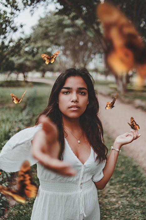 Un retrato de fotografía conceptual que utiliza mariposas para simbolizar la libertad y la creatividad