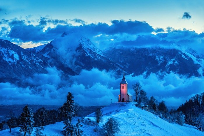 Una iglesia iluminada en las montañas. 